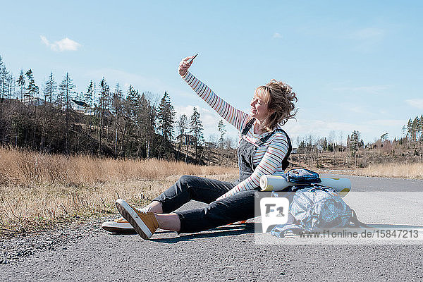woman taking a selfie whilst taking a rest from skating from yoga