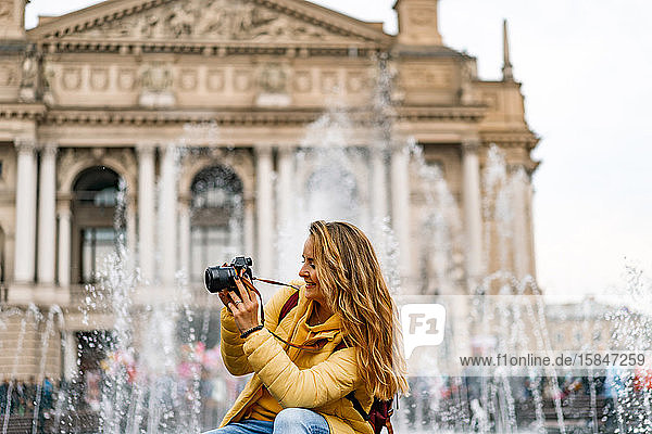 Junge Touristin mit einer Kamera beim Fotografieren in der europäischen Altstadt.