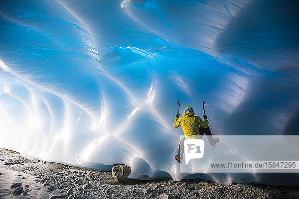 Bergsteigereisklettern auf Gletschereis in Eishöhle.