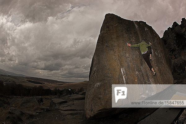 Mann bouldert auf Gittersteinen im Peak District / UK