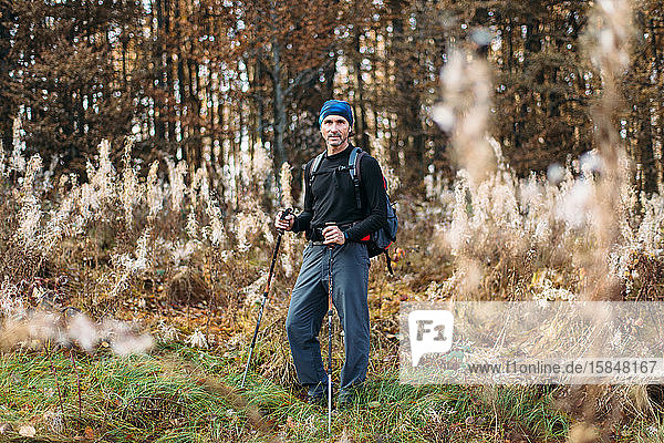 Portrait of mature man in camping equipment. Autumn forest background