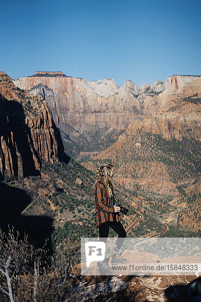 Junges Mädchen posiert mit einer Kamera mit dem Zion-Nationalpark als Hintergrund