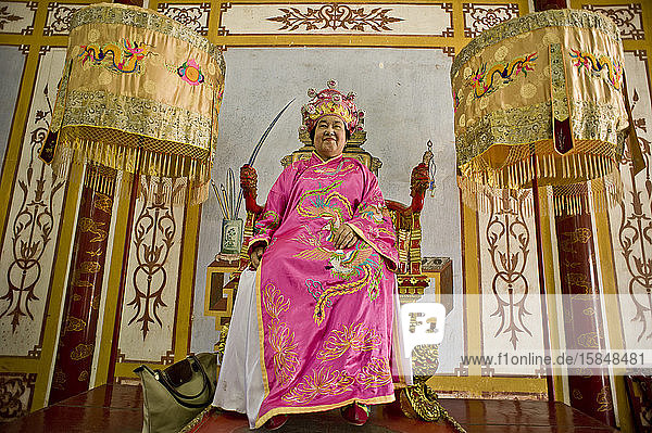 Tourist sitzt in traditioneller Kleidung auf dem Kaiserthron