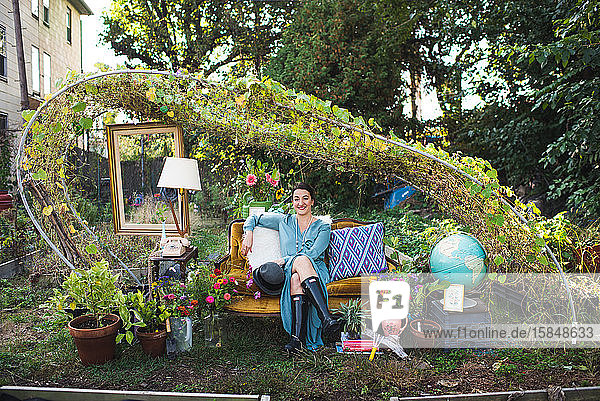 glückliche Frau auf einer Couch im Garten