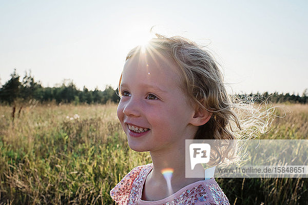 portrait of a young girl smiling outside at sunset