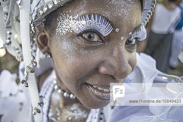 Lächelnde afro-brasilianische Frau in weißem Kostüm während des Karnevals in Rio