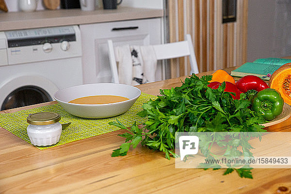 Zubereitung von Hühnerbrühe mit Gemüsebouillon in einem Topf. Schwarze Kreidetafel als Hintergrund.