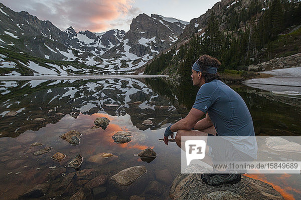 Man on run admires lake view in Indian Peaks Wilderness  Colorado