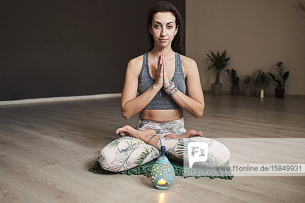 junge Frau meditiert allein im Yogastudio mit Duftlampe