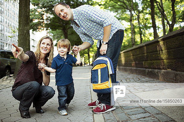 Parents walking son to preschool or daycare