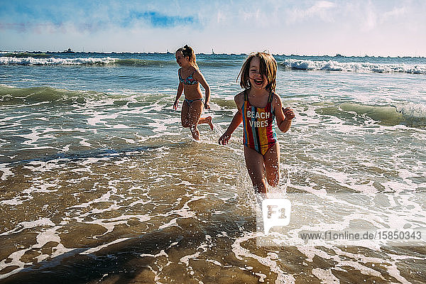 Mädchen rennen nach Flugschau in Kalifornien an den Strand