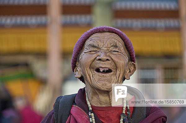 Alte zahnlose Frau lacht bei buddhistischer Feier