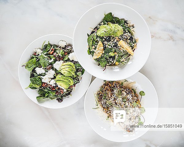 flachliegende Lebensmittelfotografie frischer grüner Salat Avocado und Blätter
