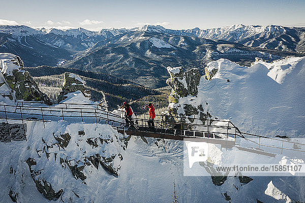 Skiers hiking on top of cliffs