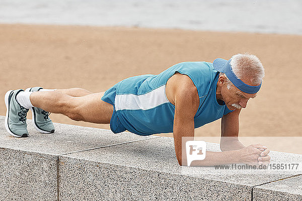 Mann übt Delphin-Planken-Pose