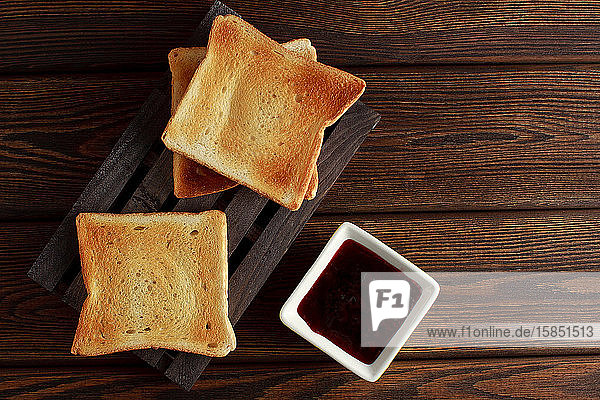 Toasts with jam on dark wooden table
