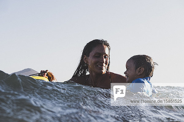 Intimate portrait of mother and son playing at sea