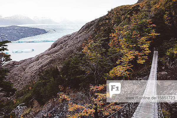 Suspension bridge between rocks next to lake