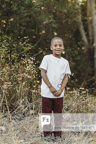 Porträt eines jungen  selbstbewussten Jungen im Schulalter  der in die Kamera lächelt
