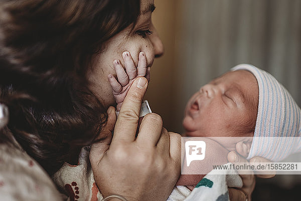Nahaufnahme der Mutter im Krankenhaus  die die Hand des neugeborenen Sohnes berührt
