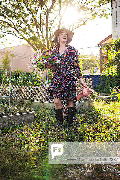 glückliche Frau im Stadtgarten mit frischen Blumen