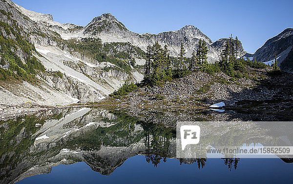 Panoramablick auf einen Berggipfel und seine Spiegelung auf einem See.