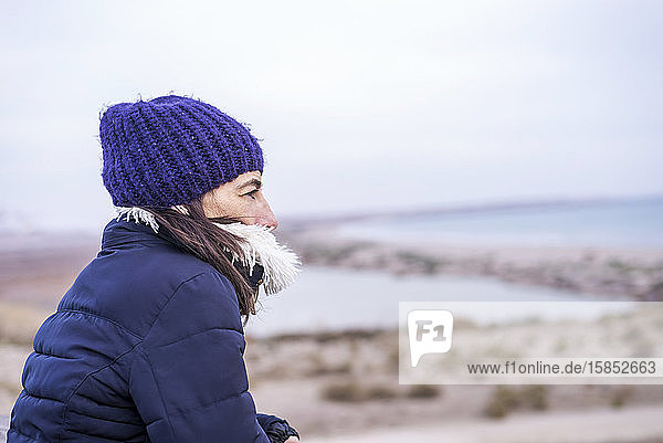Seitenansicht einer Frau mit Wollmütze mit Blick auf den Horizont