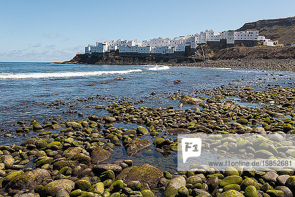 View of white house neighborhood facing the sea from a pebble beach