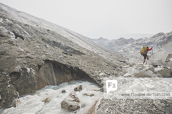 Rucksacktourist beim Wandern neben dem schmelzenden Gletscher.