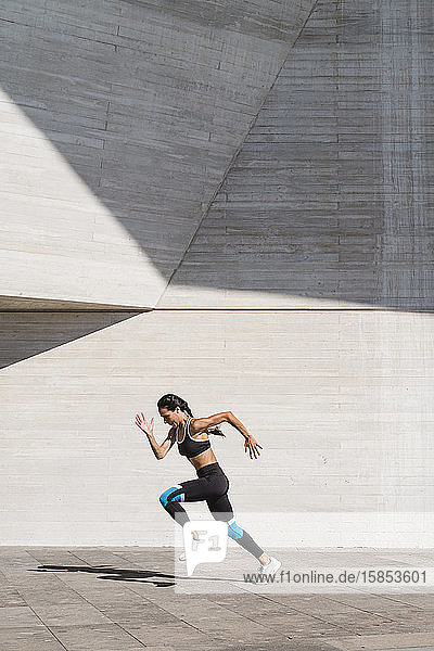 Female athlete running on concrete vertical