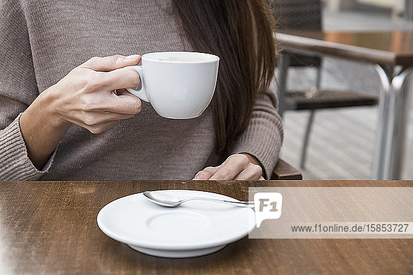 Hände einer Frau  die eine Tasse Kaffee hält