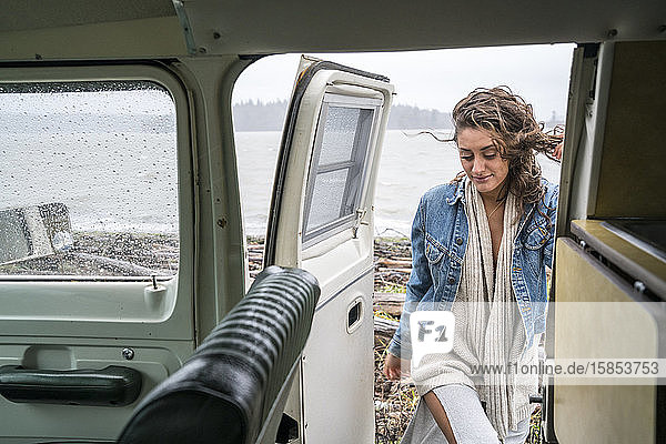 Teenagerin steigt an einem regnerischen Tag in einen Oldtimer-Van