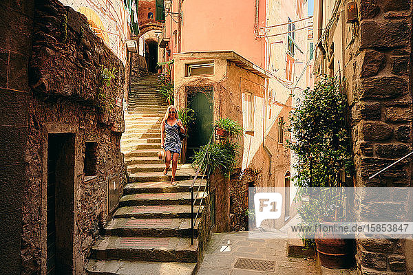 Frau geht die Treppe in einer alten europäischen Straße hinunter