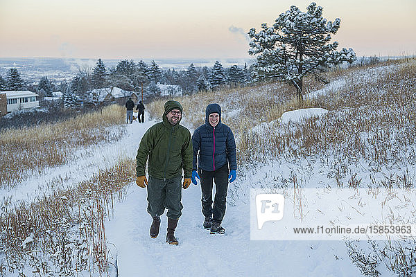 Freunde wandern auf schneebedecktem Pfad in der Dämmerung über Boulder  Colorado