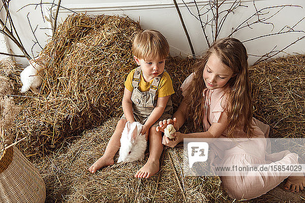 Kinder zu Ostern mit Kaninchen und Enten