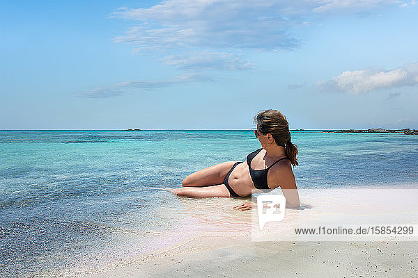 Landschaft mit Meer und einer Frau  die Wasser und Sonne am Strand von Balos genießt