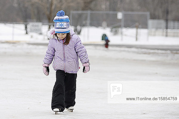 Little Girl Learning to Ice Skate Outdoors