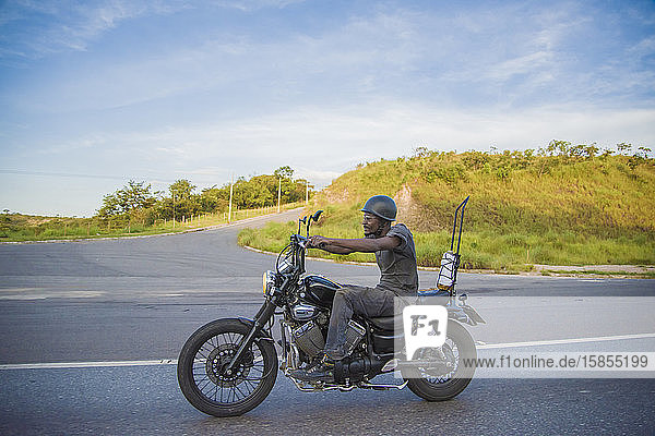 Afro-Latin man rides his motorbike in Brazilian countryside