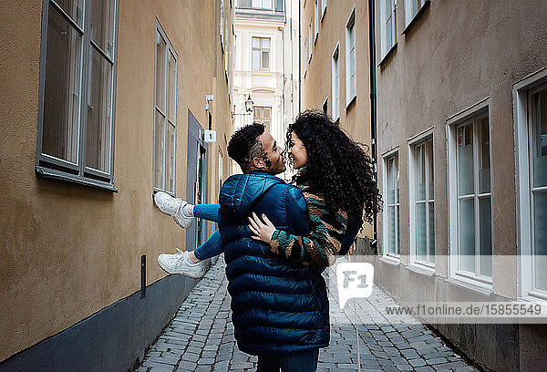 Mann  der seine Freundin verliebt durch die Straßen Europas trägt