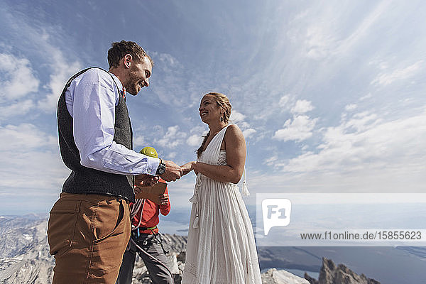 Ehepaar tauscht während der Hochzeit auf dem Gipfel des Berges Gelübde und Ringe