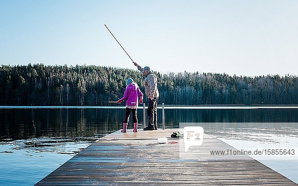 Großvater bringt seinem Enkel das Angeln in einem See in Schweden bei