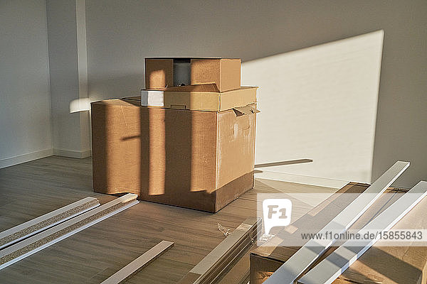Geräumiges Wohnzimmer auf leerer Etage mit einem Stapel Kisten und Reformtischen. Wohnung zur Vorbereitung der Einrichtung