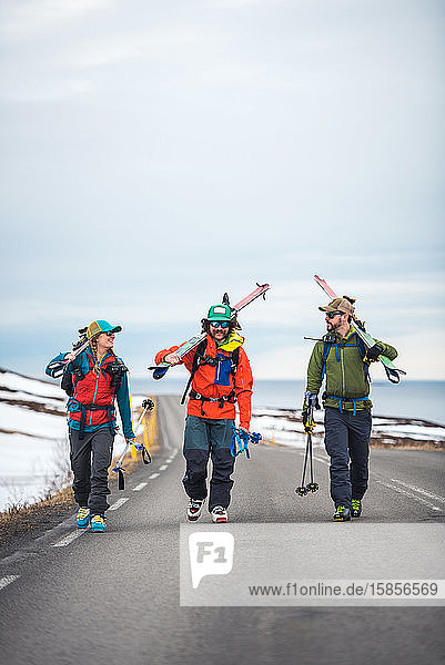 Drei Personen auf einer gepflasterten Straße in Island