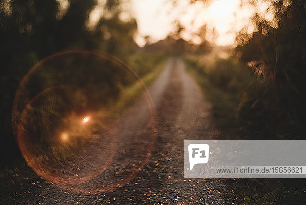 Sun Flare Bubble On Gravel Country Road Leading to Sunset