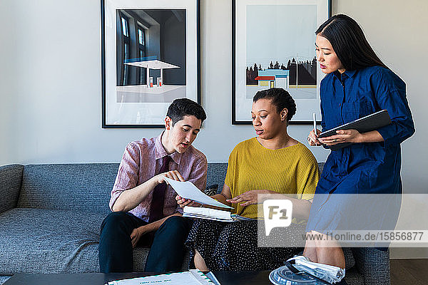 Businesswoman discussing over documents with colleagues in office
