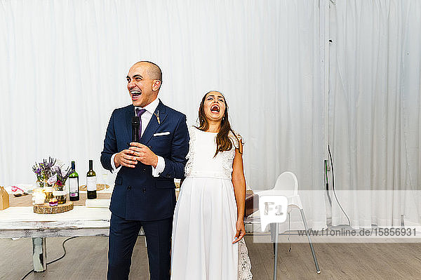 Aufgeregtes Brautpaar lacht während der Hochzeitsrede