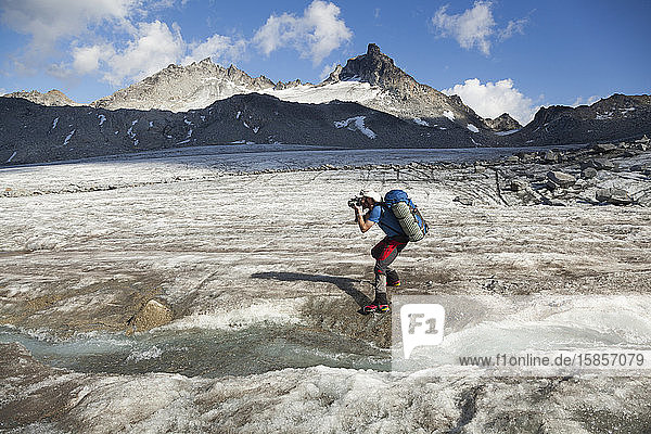 Man takes pictures on Snowbird Glacier  Talkeetna Mountains  Alaska