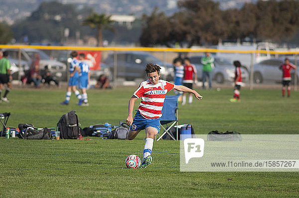 Teen soccer player about to strike the ball on a free kick