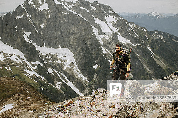 A male hiker walks along a trail in the North Cascades  Washington