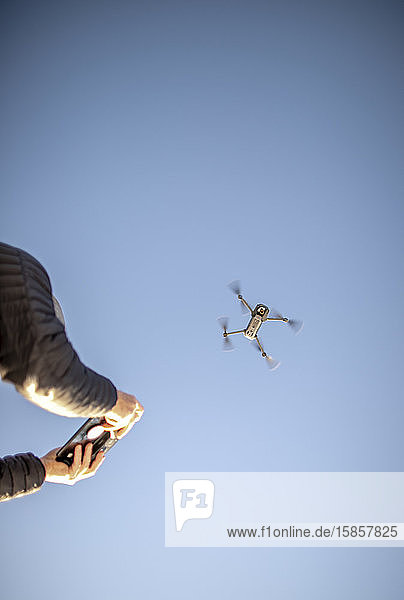 Eine Drohne und ihre Fernsteuerung sind gegen den blauen Himmel zu sehen.